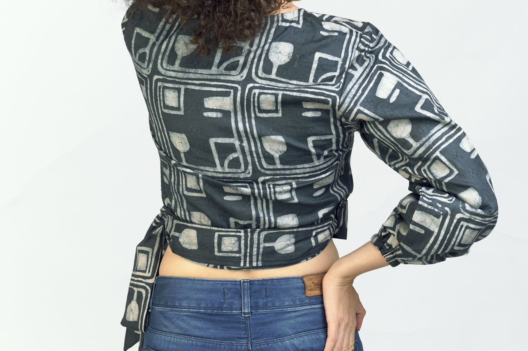 Woman wearing matching grey batik print headband and wrap top by GEOMETRIC.