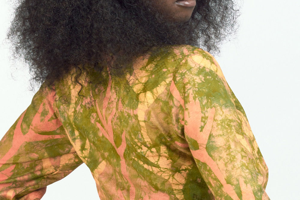 Woman wearing orange hand-dyed Birds of Paradise headband by GEOMETRIC with matching wrap top.