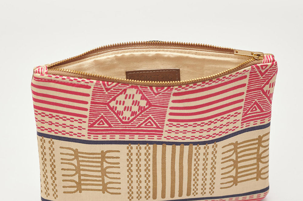 Tan and pink hand-dyed Kente print Zipper Clutch by GEOMETRIC.