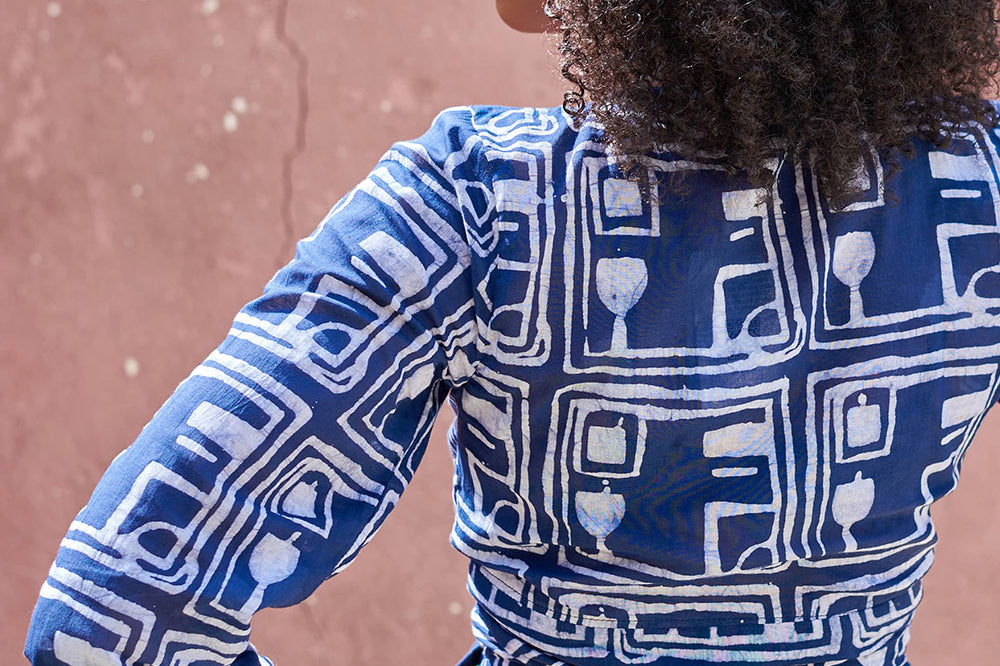 Back view of woman wearing blue hand-dyed batik Coco print long sleeve wrap top by GEOMETRIC.