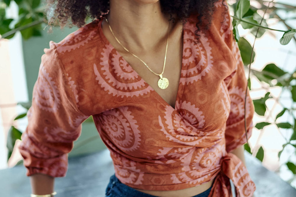 Woman wearing hand-dyed red and pink sea shell batik print long sleeve wrap top by GEOMETRIC.