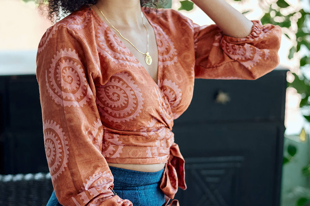 Woman wearing hand-dyed red and pink sea shell batik print long sleeve wrap top by GEOMETRIC.