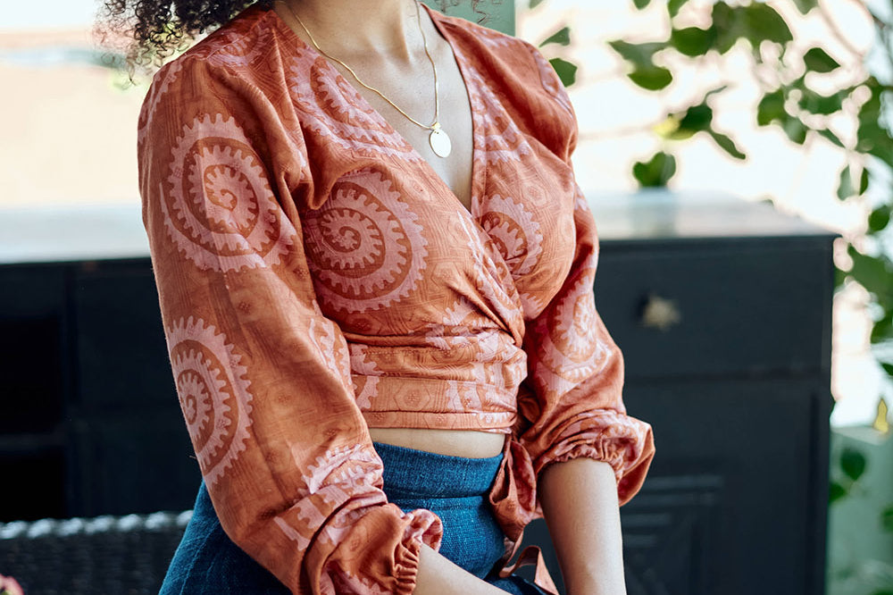 Woman wearing hand-dyed red and pink sea shell batik print long sleeve wrap top by GEOMETRIC.