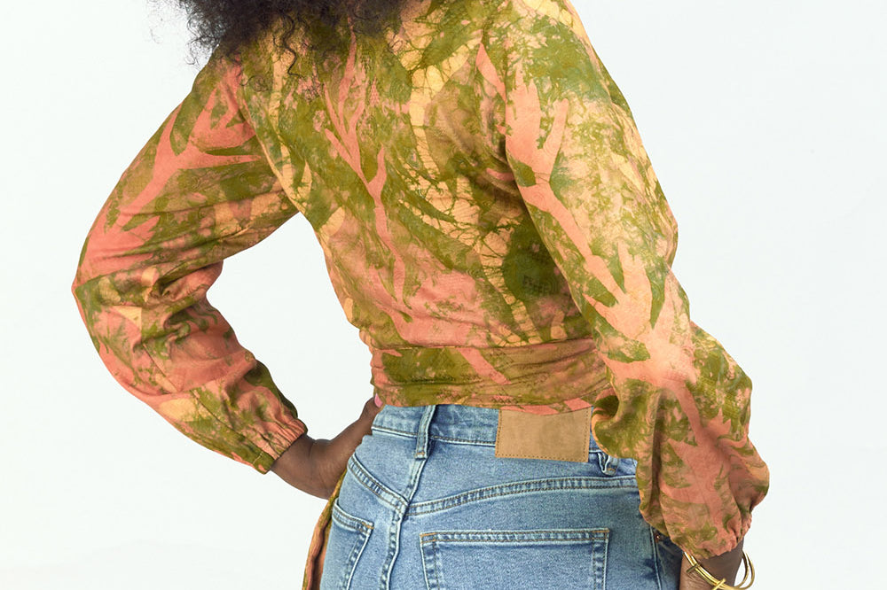 Woman wearing hand-dyed orange Birds of Paradise batik print long sleeve wrap top by GEOMETRIC.