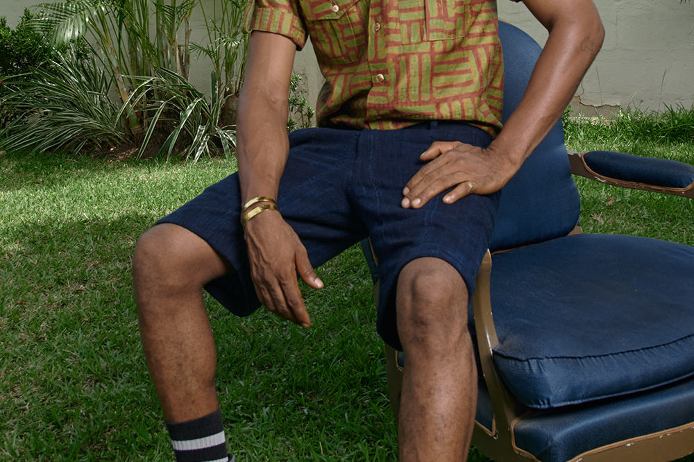 Man wearing hand-dyed green batik Garden Gate print short sleeve button up shirt by GEOMETRIC.