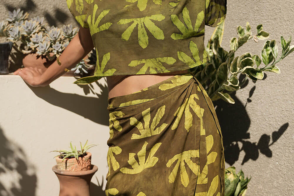 Woman wearing matching crop wrap top and wrap skirt by Geometric green tone hand dyed deadstock fabric.