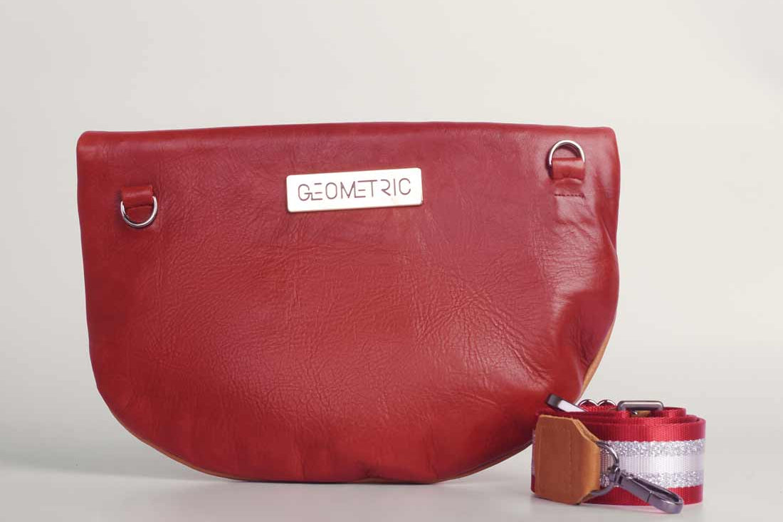 Tan and red wine leather Crescent cross-body bag by GEOMETRIC. 