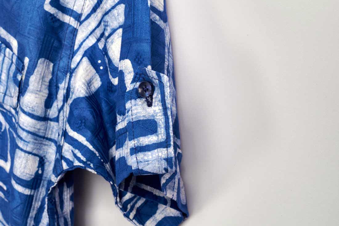 Close-up hand-dyed blue Coco batik print short sleeve button up shirt by GEOMETRIC. 