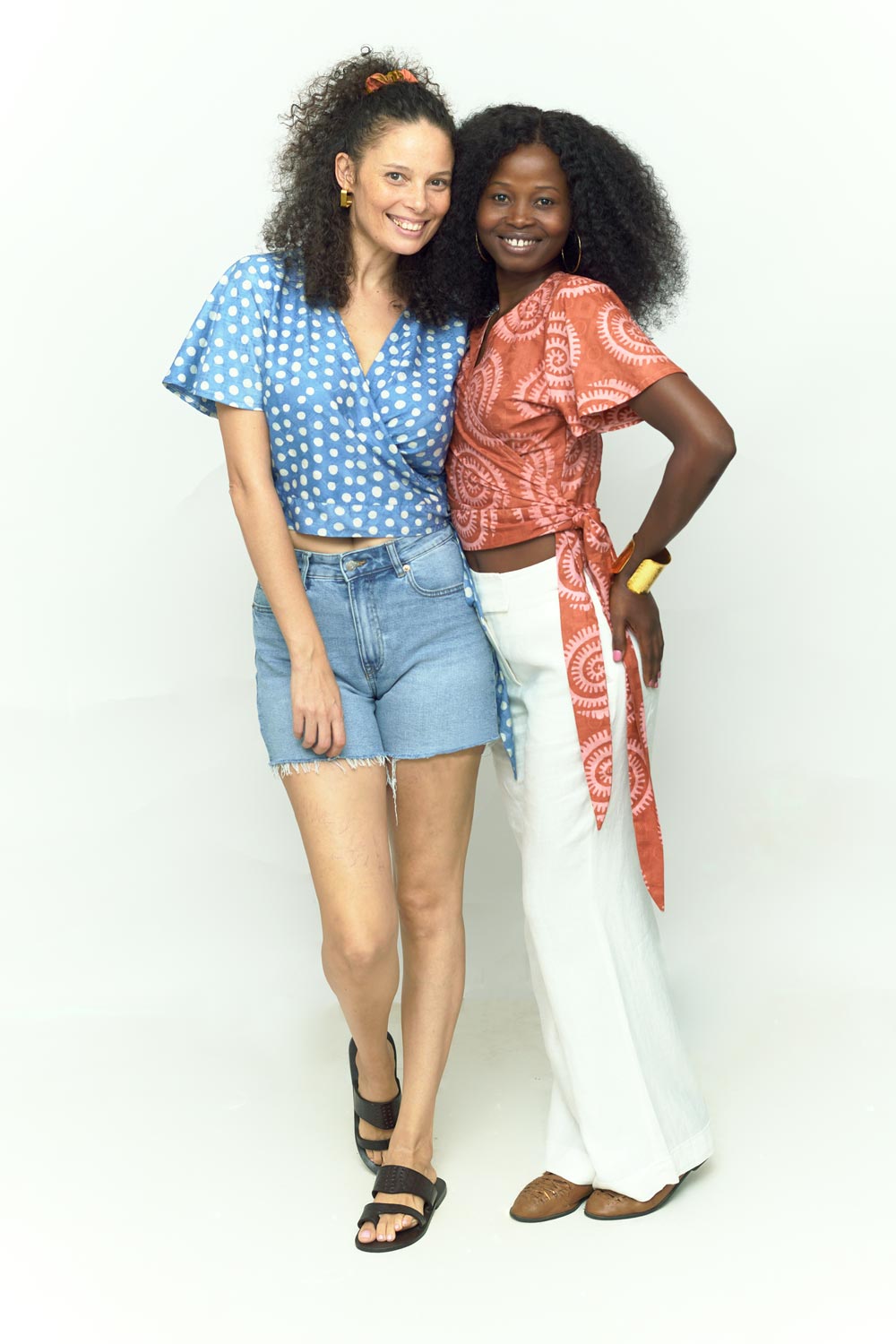 Two women wearing hand dyed batik print wrap tops by GEOMETRIC. 