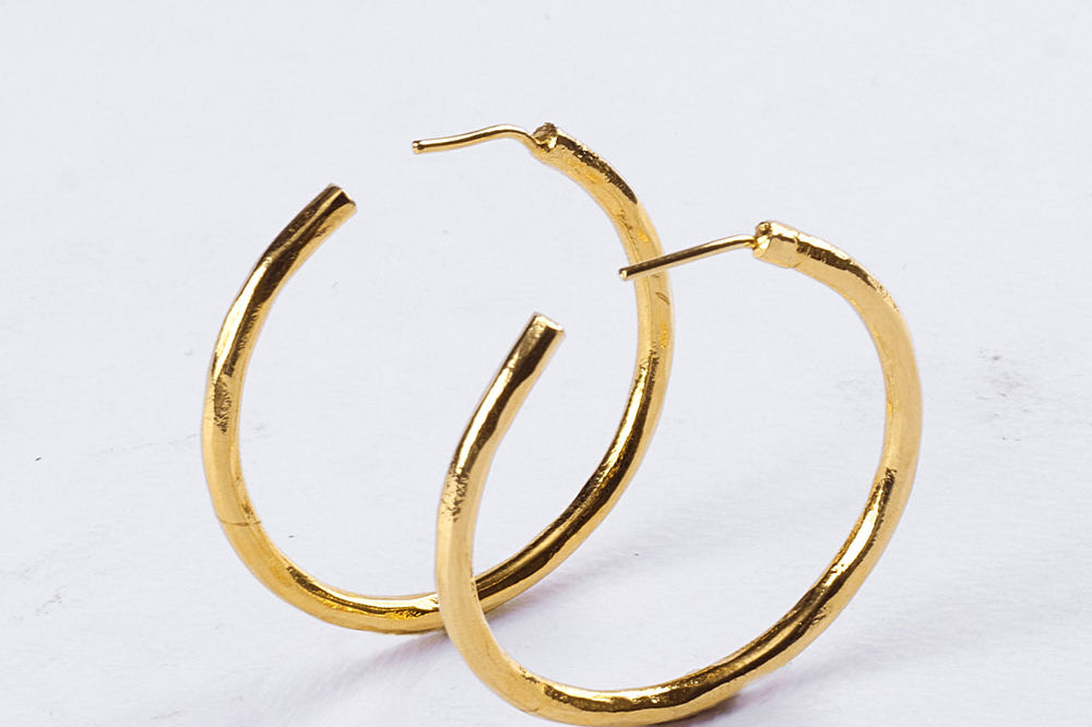 Small hammered brass hoop earrings by GEOMETRIC. 