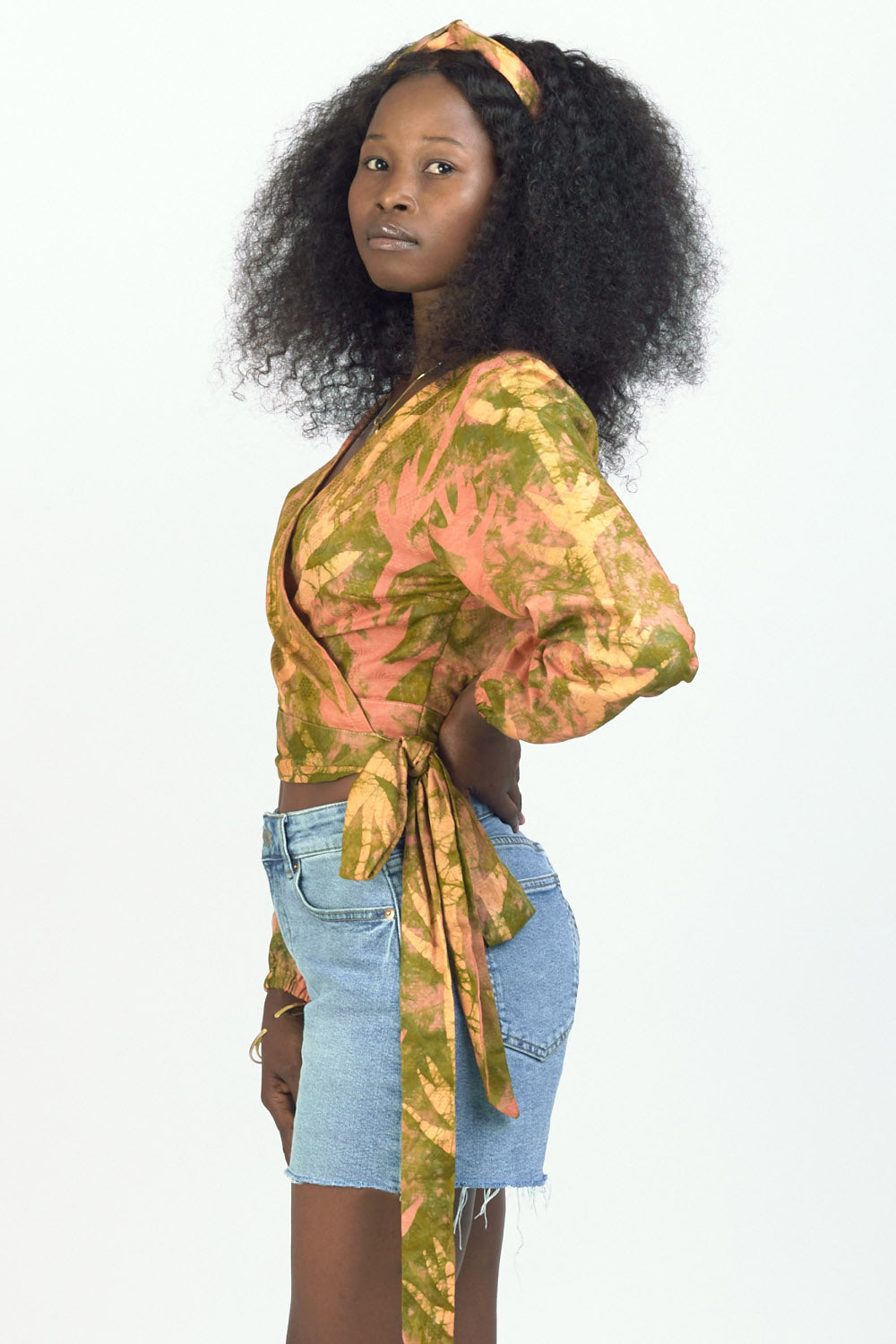 Woman wearing orange hand-dyed Birds of Paradise headband by GEOMETRIC with matching wrap top. 