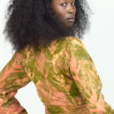 Woman wearing orange hand-dyed Birds of Paradise headband by GEOMETRIC with matching wrap top. 