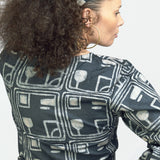 Woman wearing charcoal hand-dyed batik Coco print headband by Geometric with matching wrap shirt. 