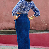 Back view of woman wearing denim skirt blue hand-dyed batik Coco print long sleeve wrap top by GEOMETRIC. 