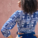 Back view of woman wearing blue hand-dyed batik Coco print long sleeve wrap top by GEOMETRIC. 