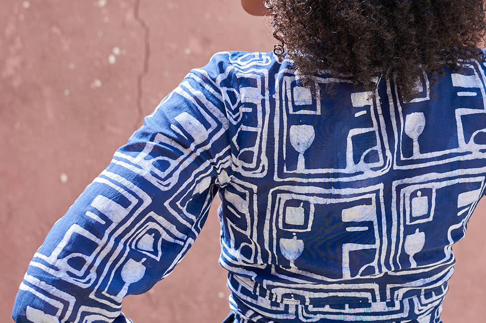 Back view of woman wearing blue hand-dyed batik Coco print long sleeve wrap top by GEOMETRIC. 