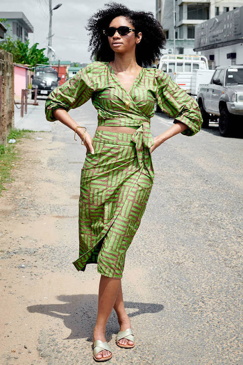 Woman wearing matching green hand-dyed batik Garden Party print long sleeve wrap top and wrap skirt by GEOMETRIC. 