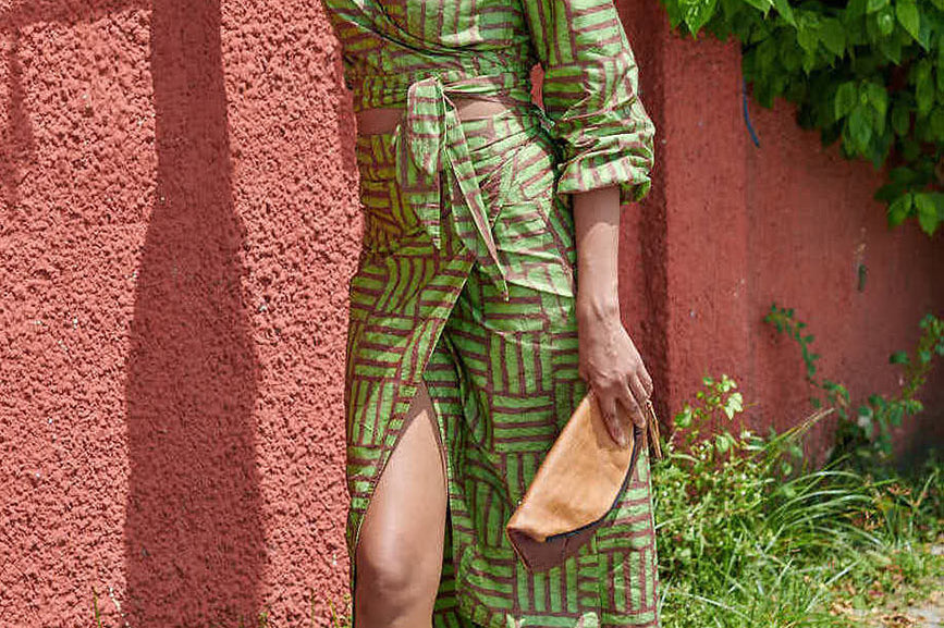 Woman wearing matching green hand-dyed batik Garden Party print long sleeve wrap top and wrap skirt by GEOMETRIC. 