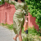 Woman wearing matching green hand-dyed batik Garden Party print long sleeve wrap top and wrap skirt by GEOMETRIC. 
