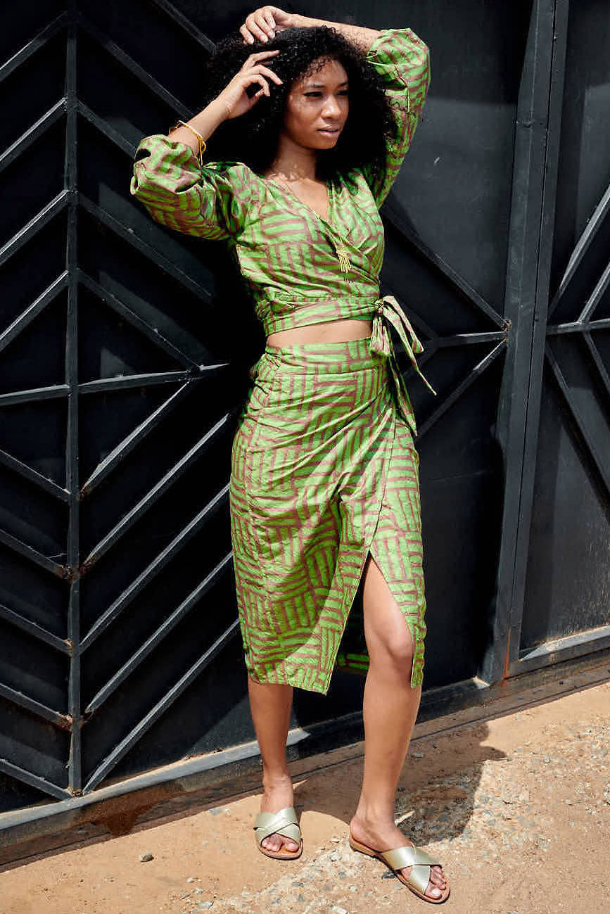 Woman wearing matching green hand-dyed batik Garden Party print long sleeve wrap top and wrap skirt by GEOMETRIC. 