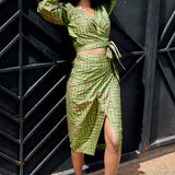 Woman wearing matching green hand-dyed batik Garden Party print long sleeve wrap top and wrap skirt by GEOMETRIC. 