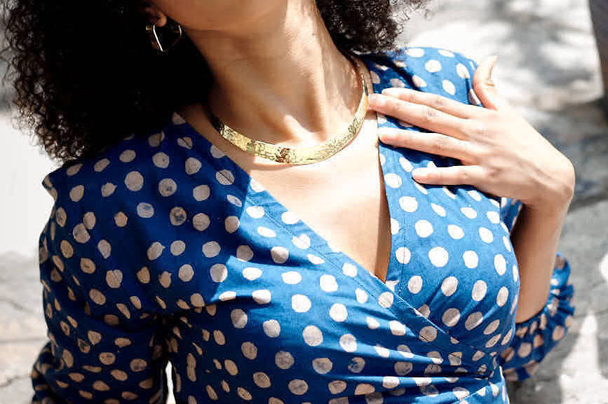 Woman wearing blue hand-dyed polka dot batik print wrap top by GEOMETRIC. 