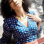 Woman wearing blue hand-dyed polka dot batik print wrap top by GEOMETRIC. 