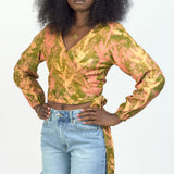 Woman wearing hand-dyed orange Birds of Paradise batik print long sleeve wrap top by GEOMETRIC. 