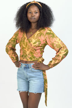 Woman wearing hand-dyed orange Birds of Paradise batik print long sleeve wrap top by GEOMETRIC. 