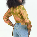 Woman wearing hand-dyed orange Birds of Paradise batik print long sleeve wrap top by GEOMETRIC. 