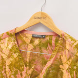 Close-up of hand-dyed orange Birds of Paradise batik print long sleeve wrap top by GEOMETRIC. 