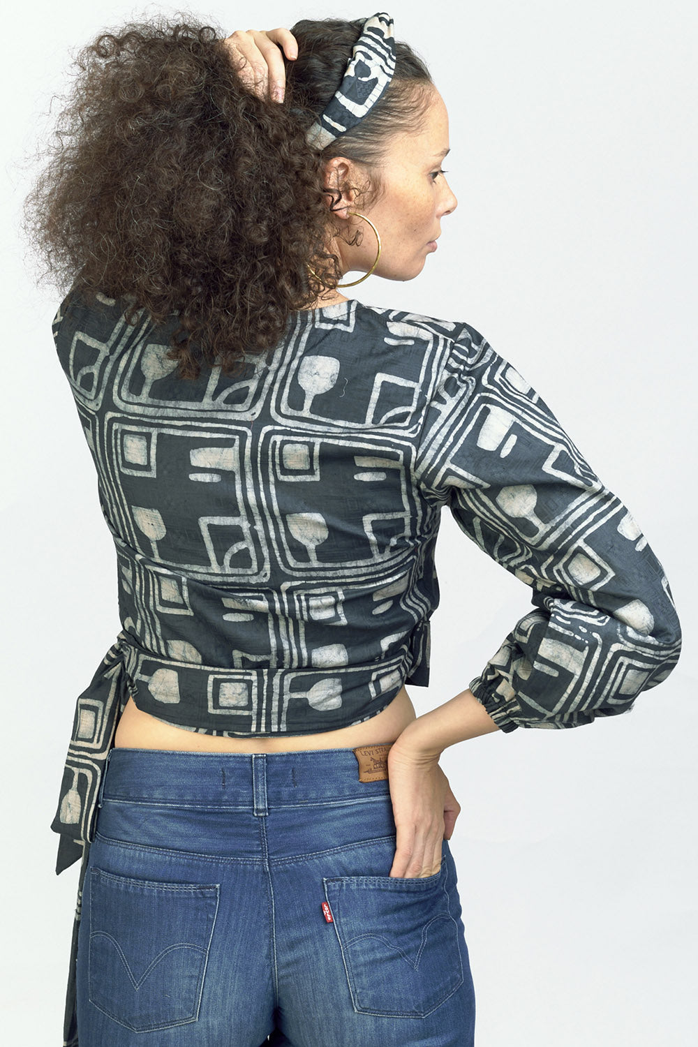 Woman wearing charcoal hand-dyed batik Coco print long sleeve wrap top by GEOMETRIC. 