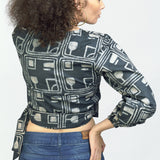Woman wearing charcoal hand-dyed batik Coco print long sleeve wrap top by GEOMETRIC. 