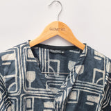 Close-up of charcoal hand-dyed batik Coco print long sleeve wrap top by GEOMETRIC. 