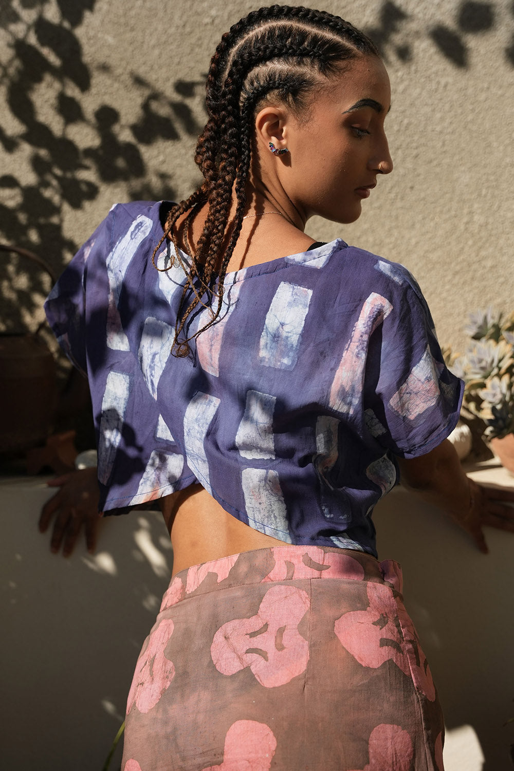 Back view of woman wearing crop wrap top by Geometric made from purple tone hand dyed deadstock fabric. 
