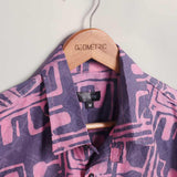 Close-up of hand-dyed purple Coco batik print short sleeve button up shirt by GEOMETRIC. 