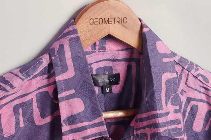 Close-up of hand-dyed purple Coco batik print short sleeve button up shirt by GEOMETRIC. 