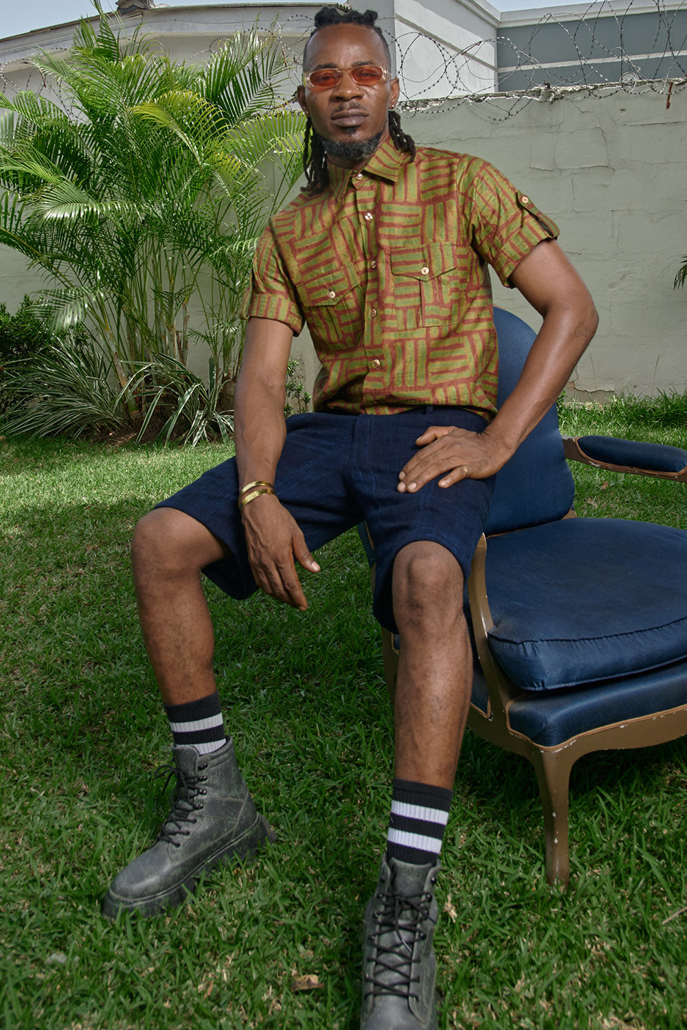 Man wearing hand-dyed green batik Garden Gate print short sleeve button up shirt by GEOMETRIC. 