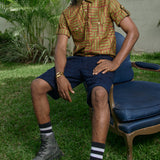 Man wearing hand-dyed green batik Garden Gate print short sleeve button up shirt by GEOMETRIC. 