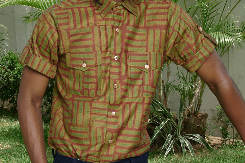 Man wearing hand-dyed green batik Garden Gate print short sleeve button up shirt by GEOMETRIC. 