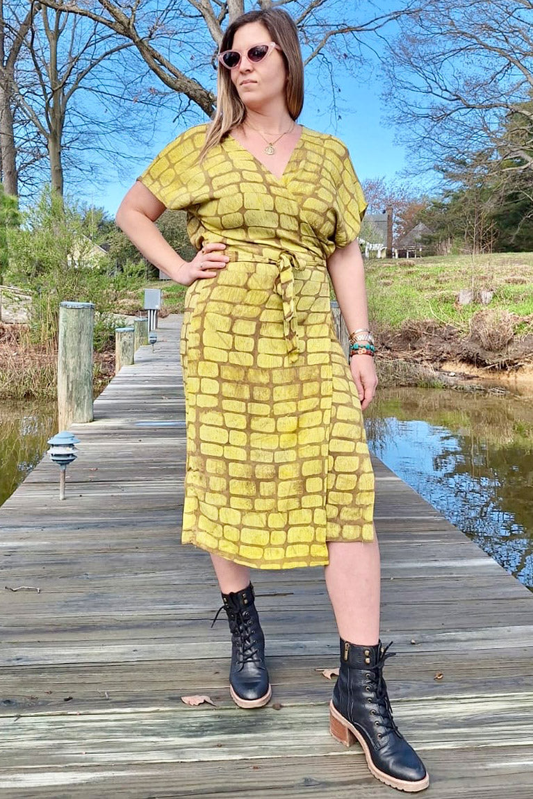Woman wearing hand-dyed yellow techno wrap dress by GEOMETRIC. 