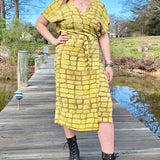 Woman wearing hand-dyed yellow techno wrap dress by GEOMETRIC. 