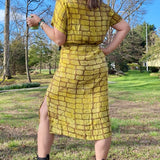 Back view of woman wearing hand-dyed yellow techno wrap dress by GEOMETRIC. 