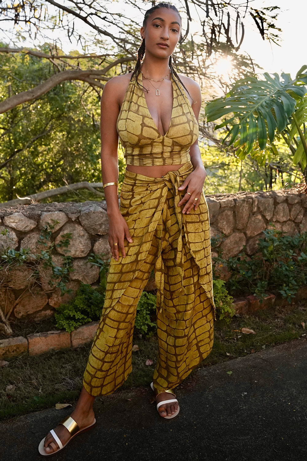 Woman wearing yellow hand-dyed batik print Technno wrap pants by Geometric. 