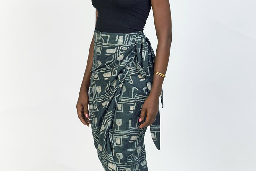 Woman wearing black tank top and charcoal hand-dyed Coco batik print Wrap Skirt by GEOMETRIC. 