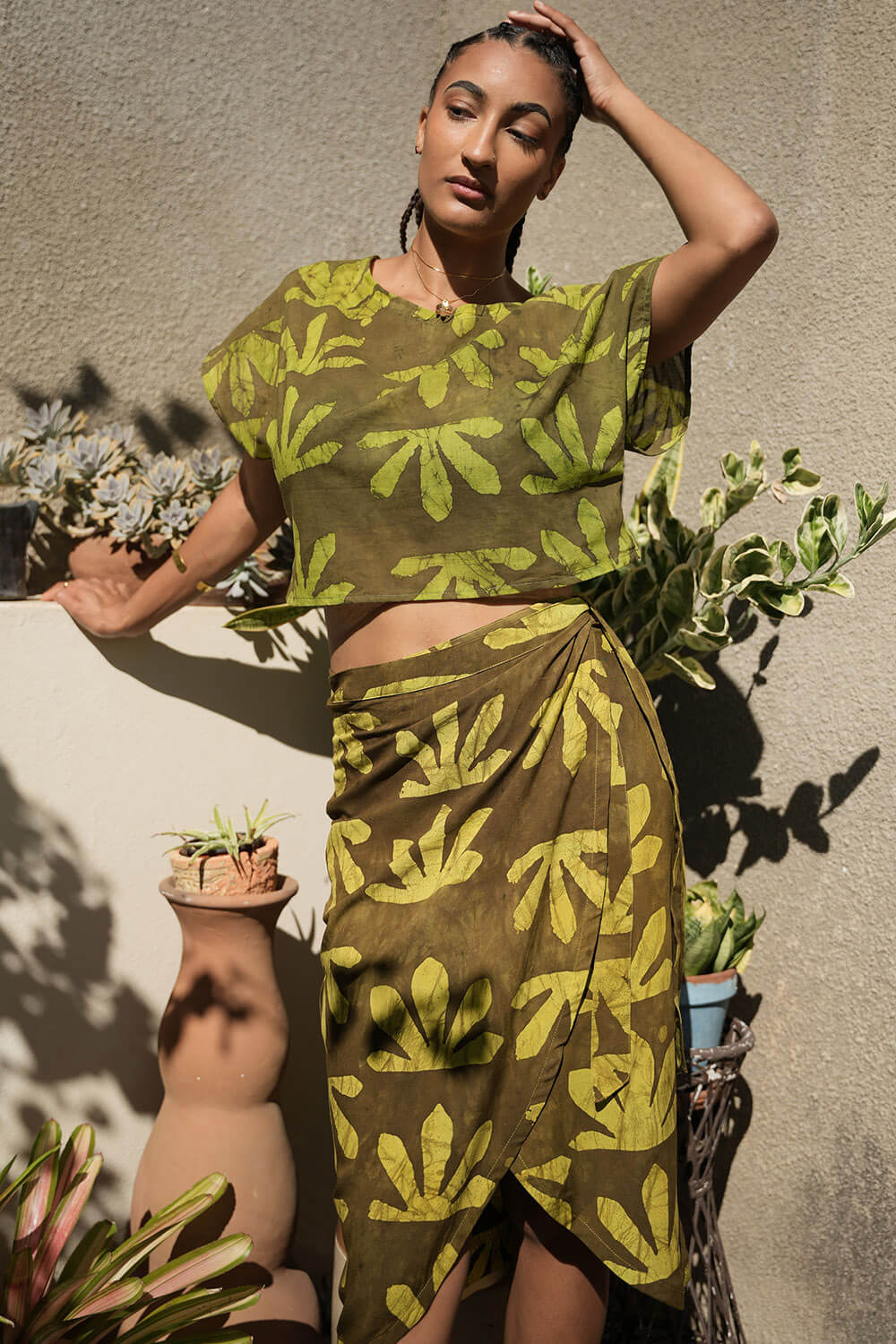Woman wearing matching crop wrap top and wrap skirt by Geometric green tone hand dyed deadstock fabric. 