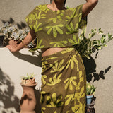 Woman wearing matching crop wrap top and wrap skirt by Geometric green tone hand dyed deadstock fabric. 
