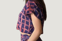 Woman wearing matching purple and pink hand-dyed Caribbean Lattice batik print Reversible Crop Top and Wrap Skirt by GEOMETRIC. 