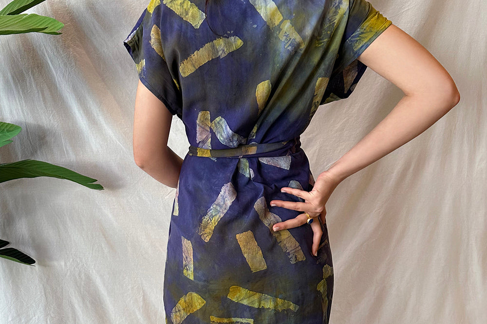 Back view of woman wearing hand-dyed navy Kaleidoscope wrap dress by GEOMETRIC. 