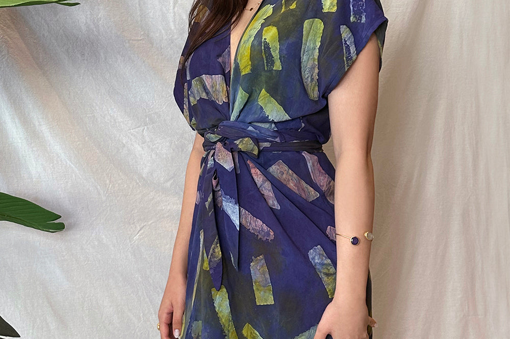 Woman wearing hand-dyed navy Kaleidoscope wrap dress by GEOMETRIC. 